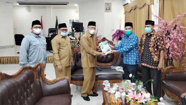 Hendri menerima buku dari Ketua DPW LDII Sumatera Barat