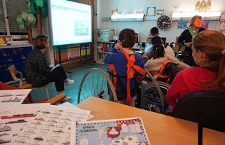 Alunos, pais e professora observam as imagens no quadro interativo