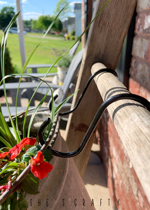 Use S hooks to hang buckets on wooden ladder.