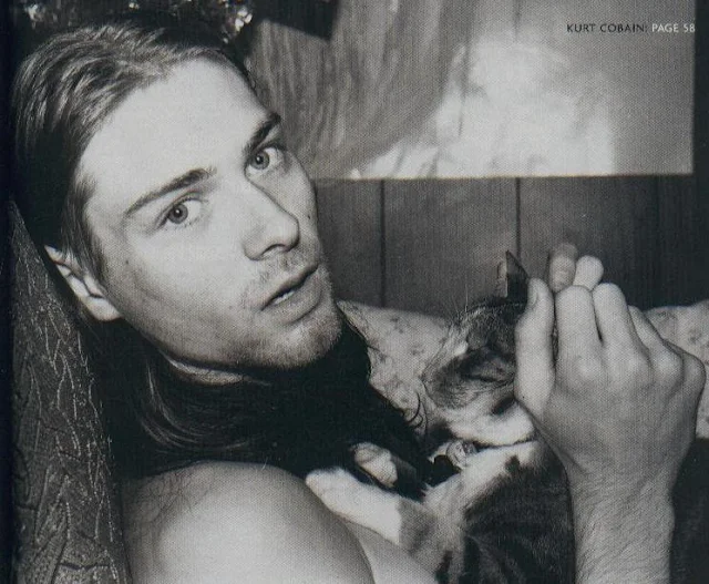 Kurt Cobain con un gato en la cama