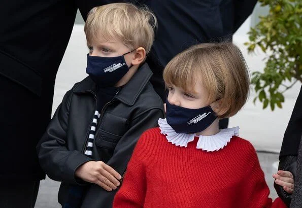 Princess Gabriella wore a red sweater. Princess Charlene wore a tropicalia toile de jouy opera coat from Christian Dior. Louis Vuitton boots