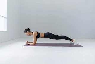 A lady doing plank on elbow active exercise in big room