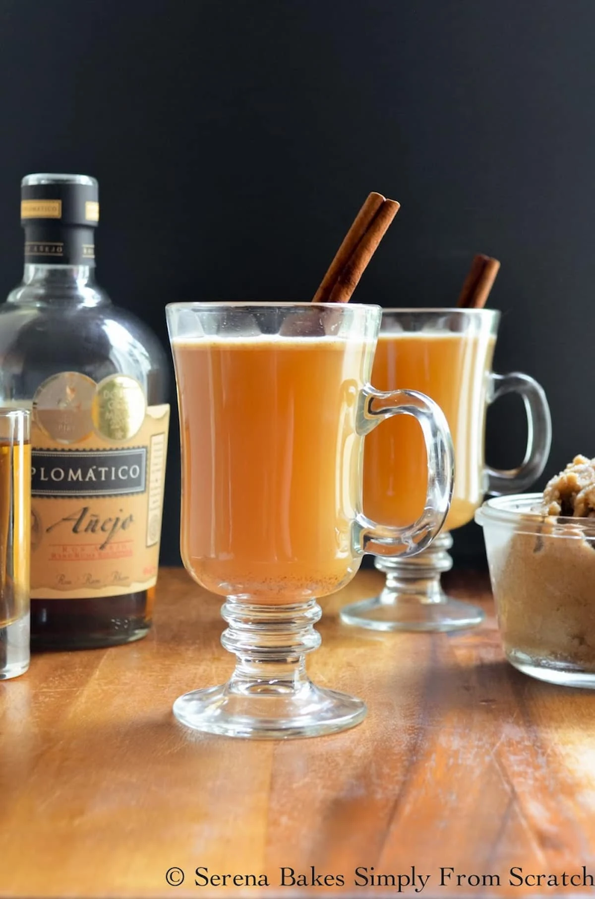 2 glasses of Hot Apple Cider Buttered Rum with a cinnamon stick.