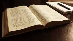 Biblia abierta, con libreta y lápiz a la par
