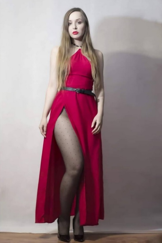 Woman wearing a red long dress, black tights and black pumps