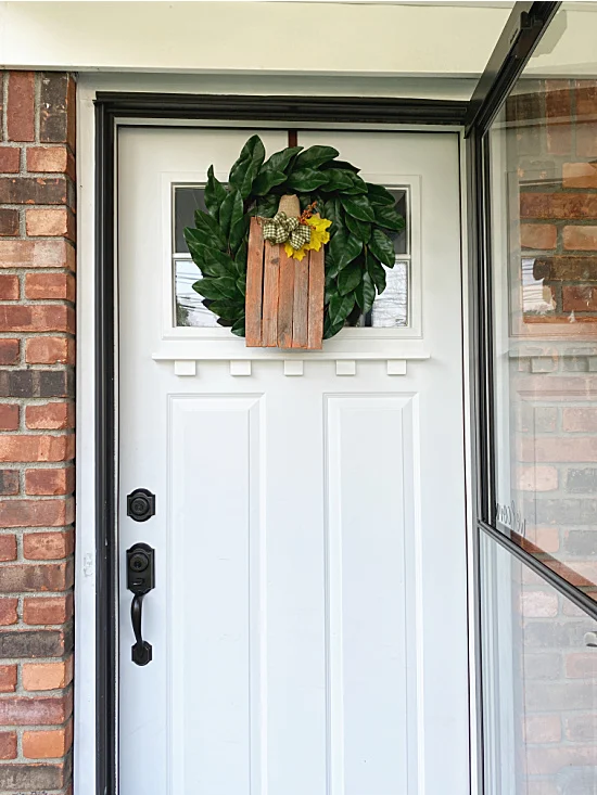 front door with wreath and pumpkin