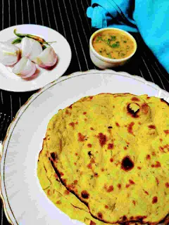 Serving Missi roti with onion, green chilli and dal in background