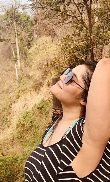 Recanto das Cachoeiras em Brotas mulher de perfil segurando o cabelo com o braço direitp em uma ponte