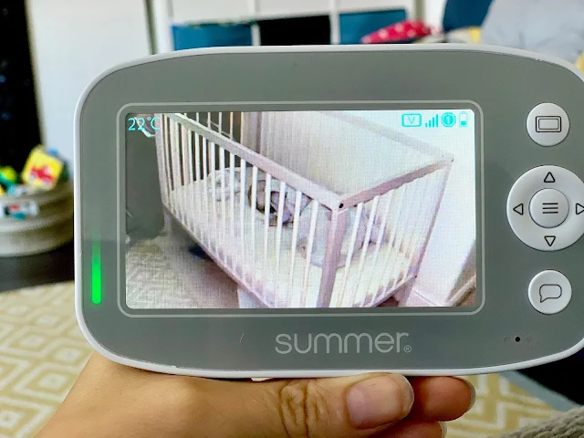 Daylight view of baby monitor showing colour and a baby sleeping in a sleeping bag and with breathable soft dog toy