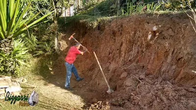 Bizzarri, da Bizzarri Pedras, ajudando a cavocar um barranco para a execução de um muro de pedra com pedras ornamentais tipo pedra moledo em sítio em Mairiporã-SP.