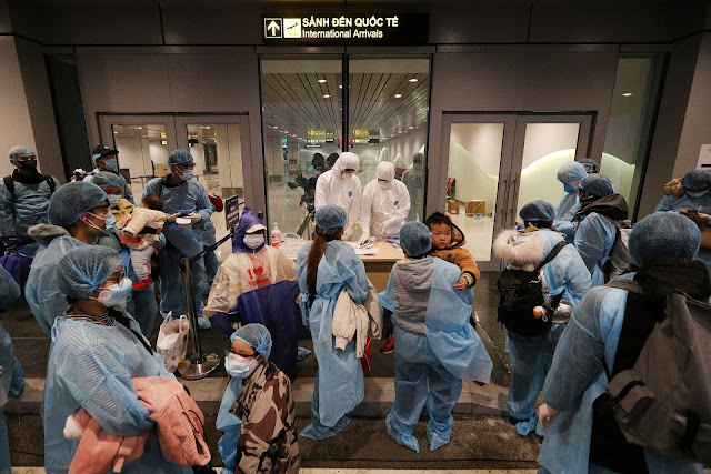 Officials inside the Van Don airport check details of Vietnamese citizens