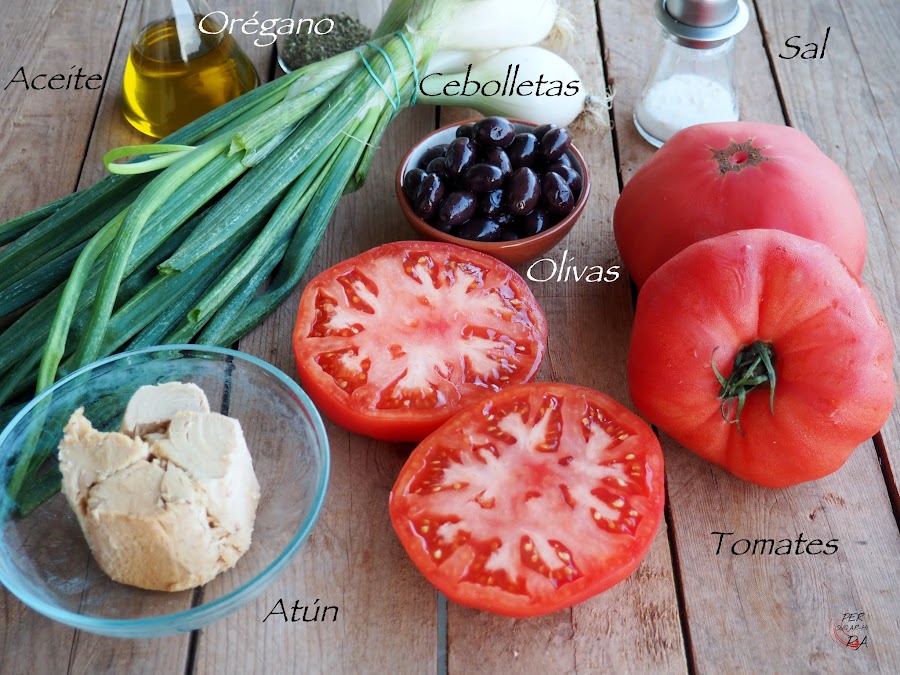 Ensalada que combina gruesas rodajas de tomate maduro, atún en aceite, olivas negras y los tallos verdes de las cebolletas frescas, aromatizado con orégano y aceite de oliva