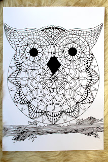 this is the image of an owl mandala placed on a fur table cloth