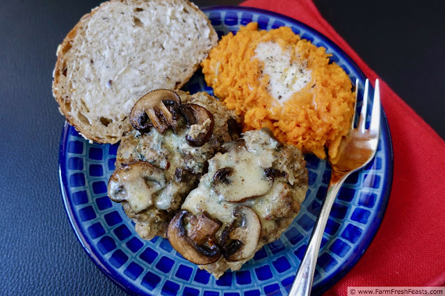 image of a blue plate with slices of bacon blue cheese mushroom meatloaf, mashed sweet potatoes, and bread