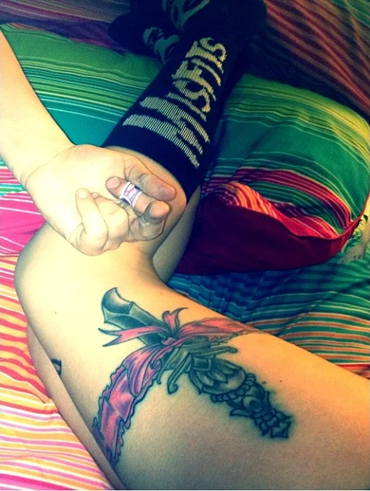 vemos a una mujer joven con tatuaje de cuchillo o tatuaje de daga