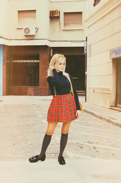 Alejandra Colomera vestida con jersey azul, falda roja cuadros escoceses, tirantes en color gris, calcetas gris y zapatos estilo colegial negro