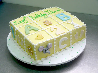 Square baby shower cake with letters and numbers on its surface