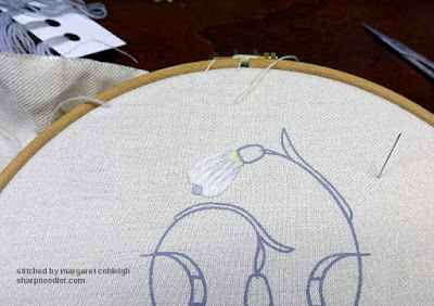 Close-up of Galanthus Collector stamped linen: uppermost snowdrop flower bud with completed embroidery