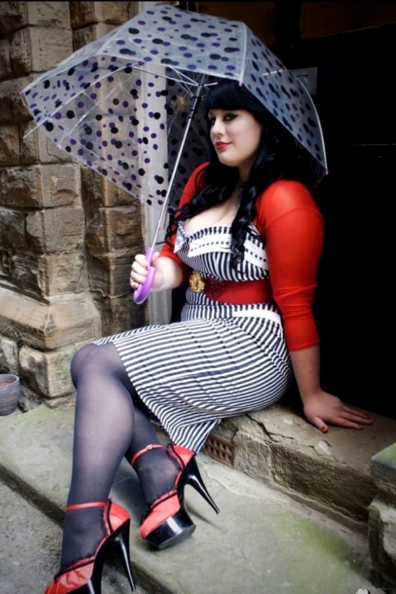 Woman wearing a stripe dress, black tights and red high heels