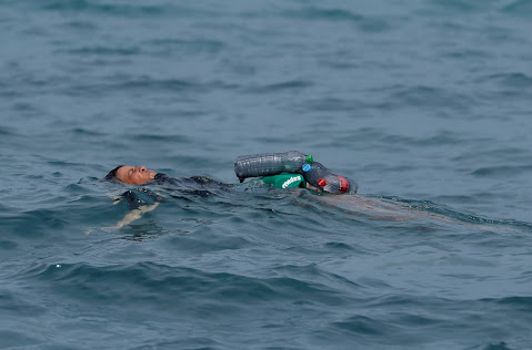 Faslı bir mülteci çocuk, plastik şişeler yardımıyla yüzere İspanya'ya girmeye çalışıyor