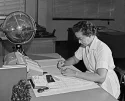 Black and white image of Katherine Johnson working at desk.