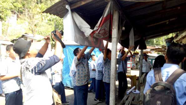 Siswa SMPN 20 Padang menurunkan spanduk iklan rokok