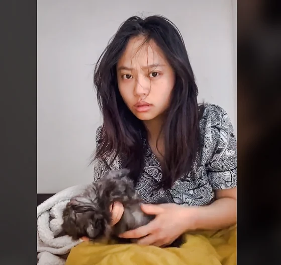 Woman looks concerned into the camera as she tries to 'revive' her kitten