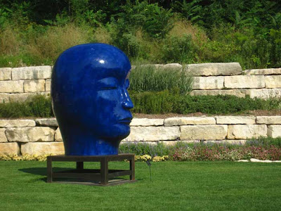Cobalt blue giant head in a garden