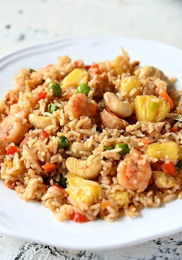 close look at a white plate with thai pineapple fried rice with lots of cashews and shrimp