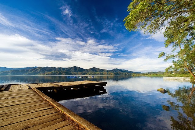 Danau Sunter landscape with green trees and calm water