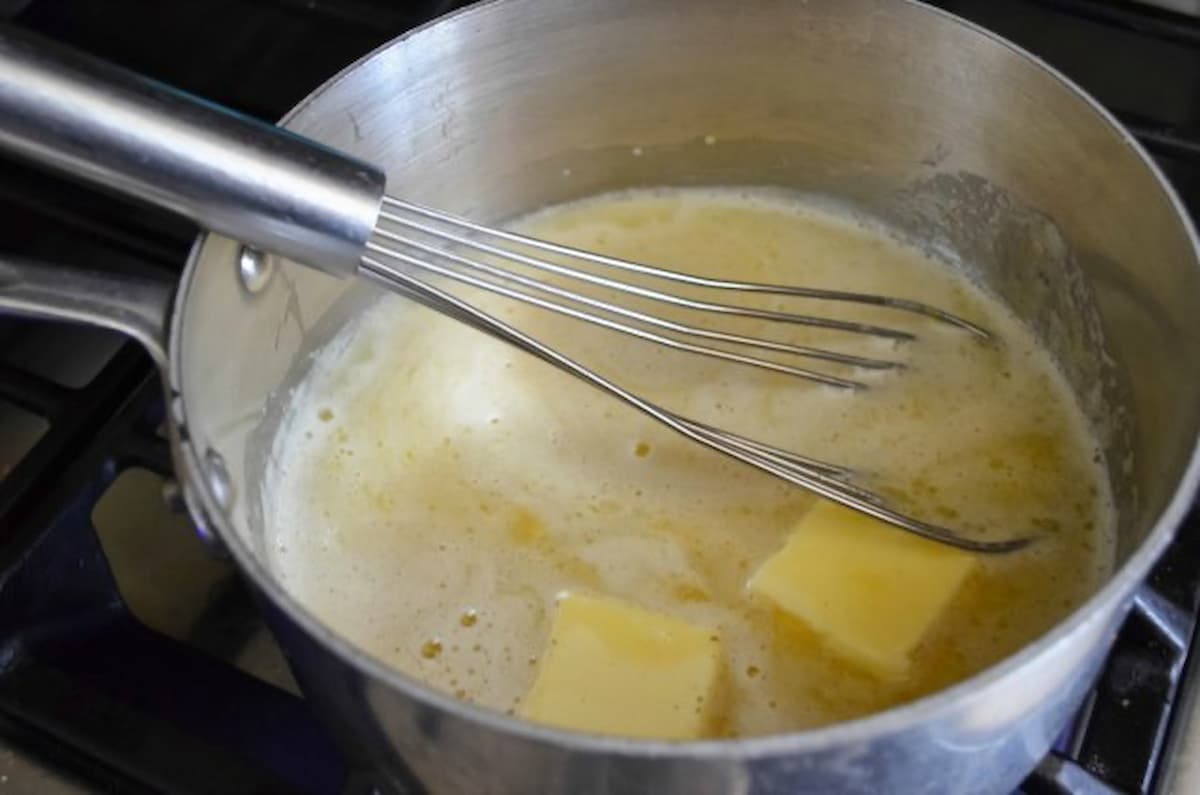 Butter being whisked into Pineapple Pudding mixture.
