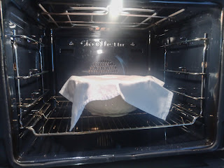 Napkin covered bowl in the oven.