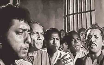 Symbolism, Power and Nationalism in Jibon Theke Neya (1970)  Md. Robiul Islam  Abstract: This is a critical film review of the film Jibon Theke Neya (1970) directed by Zahir Raihan. The review will help to understand the metaphorical meaning of the film. This review argues that the symbolic characterization of the film indicates the power and nationalism for an independent country ‘Bangladesh’. This analysis employs semiotic cinema theory and post colonial theory as the approaches to establish the argument.     Key Words: Symbolism, Power, Nationalism  “Your wife is a great politician, she has done this to get the bunch of keys”….                                                                                                                          ____ Marriage-broker  “Keep in mind, it’s my house. I will do what is needed to keep in hand the bunch of keys”…                                                                                                                             ____Lady Dictator  “Modhu, this soil is mine this soil belongs to my land, Modhu. You, I and all others were born on this soil (….) we live on this soil, and this soil is so adorable like my mother, so sacred. I don’t want this golden soil of my golden land to be tarnished that is why I always speak about my country, about soil of my land.”                                                                                                                            ____Anwar Hossain        Jibon Theke Neya (1970) is a political satire based on the Bengali Language Movement under the rule of Pakistan. Metaphorically and symbolically power and nationalism have been expressed in this cinema. Director Zahir Raihan has characterized it through an autocratic woman (Rawshan Jamil) of a family who is the political dictator and symbolizes of Ayub Khan in East Pakistan. On the other hand others have been characterized as protesting characters. Nationalism is expressed through their speech and activities.     From Previous Literature:  There are no international journals or articles about Jibon Theke Neya (1970). But few notable works about this film has been done. For example; Journal of the Asiatic Society of Bangladesh publishes an article about the film titled “Jibon Thekey Neya (Glimpses of Life, 1970): The First Political Film in Pre-Liberation Bangladesh and A cinematic metaphor for nationalist concerns” by Fahmida Akhter, Assistant Professor, Department of Drama and Dramatics, Jahangirnagar University. [Vol. 59(2), 2014, pp.291-303] But there is no inner connotation meaning or indefinite argument of the article. She only writes about the explanation of the cinema and some codes of cinema that are used in the film that indicates the nationality and Bengali’s cultural program codes. Besides, the Daily Star reports about it titled ‘Zahir Raihan and the making of Jibon Thekey Neya’ by Naznin Tithi. [19 August, 2017]  She only writes about the film making, releasing, and censor board and cinema explanation a few. The Daily Asian Age reports about it as titled ‘Jibon Theke Neya: Cinema that reflects life’ [6 November, 2017]. But it explains a short introduction of the cinema only. Daily Observer writes about it as titled ‘Jibon Theke Neya, an emblem of political satire’ by Afsana Aziz Nitol [23 March, 2017]. Here the film has been explained on the perspective of metaphor and about nationalism .The Daily Prothom Alo writes about it as titled ‘Jibon Theke Neya’, an exposure of authority’ by Farzana Liakat [25 March, 219]. This article expresses some inner explanation of the cinema and about the release of the film. It also discusses about the nationality and this kind of political film is very tough to be released under colonial regime.     Theoretical Framework:  This study employs semiotic cinema theory and pos colonial approaches to understand the metaphorical characterization and the metaphorical development of the film. It will help to understand how the symbolism, power and nationalism have been expressed metaphorically. To study the film, Ferdinand de Saussure’s semiotics, Metz and Peter Wollen’s theory, Daniel Chandler’s theory and post colonial cinema theory will be used to understand it.     The Key Ring and Symbolism:  In Jibon Theke Neya (1970), there are many important signs have been used to express the film as metaphorical film. The key ring is one of them. The matchmaker in the film tells that the key ring is the power of dictator lady. Thus her husband can know that if the key ring is transferred from one hand to another, tow will rule in the household and the dictatorship will be vanished. So, here the key ring is the main symbol in the film and it is used as metaphorically in the film. It is the main power of the household. Besides, there are other symbols that have been used also metaphorically. For example; a glass with poison that expresses conspiracy, a bell metal bowl and plate with changing sound express tyrannical activities and a jumping koi fish expresses life without water under the dictator’s rule. Besides, there are some alphabetical sings have been used in the film. Different kinds of posters, writings, ‘Ekhushe February in Bengali language (21st February), Shahid Minar (Martyred Monument), flower, bare feet, new born baby ‘Mukti’ of Faruk and Bithi that expresses a new hope and many have been used here. According to Ferdinand de Saussure sign is the total of signifier and signified. Here signifiers are image of these symbols and sound on the other hand signified is the concept that comes in mind hearing the sign. All the different signs have their own connotative meaning. We will discuss it later. Christian Metz and Peter Wollen used the concept of semiotics to study cinema. They argue that ‘shots are the signs in cinema. This is called short circuit sign because the signifier and the signified are almost identical in cinema sign (shot).’ In the film Jibon Theke Neya (1970) all the symbols are identical. They always express something metaphorical meaning. We see the first shot of the film where Anwar Hossain writes ‘Ekhushe February’ (21st February) on a poster that is also identical. It expresses Bengali language speaking people. It is also an important symbol in the film. But the key ring is the main symbol to identify the connotative meaning. Christian Metz said that it is not because cinema is language that it can such fine stories, but rather it has become language it has told such fine stories.[Metz, Film Language, p.47]. Zahir Raihan’s cinematic styles is less important that its message because it has a fine story. It expresses Bengali nationalism with the above signs. Films manage to communicate meaning in two different manners. One denotative meaning and the other is connotative meaning. In the film there exist the two meanings. In denotative meaning, we see the image, hear the sound and easily know the signs of the cinema. But in connotative meaning, we have to explore the implicit meaning of the signs. Connotative meaning expresses the metaphorical meaning of the signs. Thus the film expresses the metaphorical meaning with the help of connotative meaning of the signs. In semiotics theory connotative meaning has two axes for example, Paradigmatic connotation and Syntagmatic connotation. We will analyze the whole film with an important symbol for example key ring. It is the paradigmatic connotation and how to present it is syntagmatic connotation. Cinematic signs have three kinds of orders that Peter Wollen suggested in his book ‘Signs and meaning in the cinema (1969). Jibon Theke Neya film covers all the orders here for example icon, index and symbol. We discuss about the posters as icon of the film and Amor Ekushe (Immortal Twenty First), Alponas (geometric flowery design), Krishnachura trees and Shahid Minar (Martyred Monument) are the index of the film that have directly relationship with Bengali Language Movement, in 1952. Women wearing Shakhas indicates the conventional symbol in the film. This indicates Hindu religion in the film. The Hindus and Muslims go to martyred monument to with flowers to respect them on bare feet. We also can know the psychological condition of a man or woman. We can know the hotness and coolness by index and symbol. We can guess the psychological state of the hot tempered dictator lady by index and symbol. On the other hand the positive state or cool mind state is revealed of two sisters and two brothers. So, index in cinema is very important to understand the relationship of coolness and hotness of human psychological state. Daniel Chanlder (2001) in his book ‘Semiotics the Basics’ said that codes organize signs into meaningful systems which correlate signifiers and signifies through the structural forms of syntagms and paradigms. Stuart Hall said that there is no intelligible discourse without the operation of codes. Actually three kinds of codes are used in cinema. In Jibon Theke Neya movie, the codes are used precisely. Now we will find the metaphorical meaning through the codes and also know the types of codes. Social codes are divided into several types of codes. For example, verbal codes, bodily codes, commodity codes, behavioral codes. In verbal codes, we see only the dictator lady speaks about her power and wants to dominate all time. The dominated member of the family cannot talk about their rights. In bodily codes, for example, lady’s husband tells his brother in-law shoutedly about Shathi so that Lady cannot know the bodily expression from other room that,  ‘Deadly, deadly, women are deadly’.  But he silently and bodily tells his brother-in-law that,  ‘You don’t listen to my words’  We can know the fashions, clothes of Anisur Rahman a lawyer, Faruk, Bithi students, the matchmaker, police, Anwar Hossain, the dictator lady and all others. We also see the cars when Anwar Hossain goes to jail and newly married Shathi goes to her husband’s house with different cars at the same time. These commodity codes express the melodramatic scenes. In the second stage, the use of painting, romanticism between Faruk and Bithi on the other hand Anisur and Shathi, the realism of slogan and meeting and protests are all of textual codes. The posters (Textual codes) are also expressing the revolutionary state. The last stage, interpretative codes are perceptual and ideological codes. We can know the perception of human psychology through perceptual codes for example, the character’s ear, eye, nose and lips. What they hear and what they listen. In the film the dictator lady only speaks and the other members cannot speak only they hear through their ears and see through their eyes. Through ideological codes, we can understand and think any kind of ism or ideology for example on the perspective of this film; racism, socialism, nationalism and power. The ideology of this kind of subject comes to our mind and can know that kind of ideas.  Power in Jibon Theke Neya:  You have a lot of power. But you cannot take it for a life time if you are tyrannical. Jibon Theke Neya is a political film that expresses Bengali nationalism. This film delivers two kinds of statements one is inside the house and other outside the house; domestic and public. The women are struggling inside the house to take over the power and the men are struggling for their rights, their democracy, independence and freedom. So, there are revolutionary activities inside the house and in the public at large meaning. Zahir Raihan makes its ending through two family’s activities. In one side, Anwar Hossaain and his sisters are protesting characters. On the other hand the dictator woman’s house, the members are silent and oppressed members. But in the last stage we see all the members are protesting characters except the dictator lady. No one can tolerate the oppression of the autocratic lady’s rule in the house. So, the two brothers get married so that the key ring is transferred and peace comes to their house. But desire of power is eternal to the dictator lady. So, she conspired to kill her sister-in-law to get the power. We can understand her oppression and abuse of power through her dialogues.     Woman:   Where have you been in so early in the morning like a thief on bare feet?  Faruk:      As today is the 21st February, I went to a Provat Feri.  Woman:   21st February? What type of thing is this?  Faruk:       Don’t you really know what is 21st February?  Woman:   I don’t need to know. It seems like a barbarian you danced on bare feet on the whole                      street, didn’t you? Listen, knowing that these of thing I can’t tolerate why did you go                     there? Remember, if you go again there, I’ll close down your study!     This is one kind of proof that how a sister behaves with her brother. And she does not know what 21st February is. Only a dictator can speak in such a way. Actually, she symbolizes the political dictator ruler of then East Pakistan Ayub Khan. The lady’s characterization has been expressed based on the West Pakistani military dictatorship of Ayub Khan from 1958 to 1969. The dictator lady’s character will be displayed through anther her dominated activities on her servants. The male servant Keramot has spent much oil. So,     Woman:             The price of milk and oil is being cut off from your salary.  Woman:             who has taken this glass here? Haven’t I told hundredth days no one will bring                              this glass from my home, if you touch it any more, I told, I will cut off your                               hand.  Not only this but also she does not stay behind oppressing her husband when he sings on the roof. He cannot sing song inside the house for her wife’s oppression.     Woman:              Noh, after breaking the tabla and harmonium a lot of times, cannot you                               understand that singing in this household is forbidden?  Woman:                Ah ha ha ha! What my truthful husband! When you get obstacle telling a lie,                                 you don’t feel shy eating my brother’s earning sitting in this house? When my                                 brother is an advocate, you rather can do clerkship of him. Either you will do                                 clerkship from tomorrow neither the whole day will stand for clients under                                   the banyan tree. You cannot sing.  Dictator Lady’s brother Anisur Rahman earns well at the advocacy profession. But he is not also free from her oppression. He starts smoking inside the room.     Woman:                What is the matter at last you are starting smoking? Today smoking, tomorrow                                 wine another day perhaps will see card chat. Did I spoil these years                                 behind you for this? As if I do not see smoking from tomorrow.     The family members cannot speak against her. If anyone does that, the dictator lady shows her power upon them. In the film once her husband affixes the poster over the wall of the house and all the members have to tolerate her oppression. ‘No autocracy’, ‘have to give singing right’, ‘must have to give husband’s right’ these points are written on the poster.   Woman:               Keramot, Anis, Faruk, what are these? Who has affixed them? Who? Who?                             How dare he? Who has affixed them? Why doesn’t reply? I gave an hour over                             whose walls the posters are affixed will be cleared through water. Otherwise,                             your rice, breakfast and entering into this house will be closed down from today.       For taking ruling power of the house the dictator lady can do everything. She always gets fear that when her ruling power is transferring. So, she was not agreed to make marry to her brother at the first time. But when her brothers by force marry to take ruling power (the key ring) over new bride, she is bound to give the power over her. But at first she does not let the new married husband wife to unite at their room.     Woman:              That is not good don’t I understand? If I let her to unite with him today, from                                   tomorrow laughing will be started, from the next day house’s matter will be                               come out, then will see taking the key ring of this household from me will tied                                 up at the fringe of his wife. Remember, it’s my house. I must do what is                               needed to keep in hand the key ring.  In Jibon theke Neya cinema, Zahir Raihan has given the total power upon the autocratic lady. So, the family members or anyone do not get power to speak against her. But a new hope is kept in nationalism chapter where the women members struggle inside the house and men members outside the house. We discuss it in the nationalism part.  Nationalism in Jibon Theke Neya:  The main hero of nationalism in the film is Anwar Hossain. Besides, Faruk, dictator woman’s husband (Khan Ataur Rahman), Modhu are the other protesting characters in the film. Never power is stayed to an autocratic person for the whole time. Its religion is changing or transferring. Either the ruler is autocratic or democratic he/she must leave the position. In the film Zahir Raihan upholds the autocratic woman as the character of the then Pakistani military dictator Ayub Khan. This film is directed inspired from Bangle Language Movement occurred in 1952. Bengali people have tolerated many oppression of the autocratic ruler Ayub Khan. And the film is the ardent proof. Bengali people never forget that kinds of oppression. Now we will discuss nationalism with the help of post colonial theory. As in 1970, Bangladesh was a colony of West Pakistan, it was then under colonialism. Indian subcontinent was under colonialism of Britain. But Indian subcontinent is divided between India and Pakistan in 1947. India becomes independent. But still Bangladesh was under Pakistan. It was a province and the West Pakistan started its oppression over East Pakistan (Now Bangladesh) through economically, politically, socially, culturally and religiously. West Pakistan deprived East Pakistan from every important sector. This film is the flaming proof of it. Now we will try to explain nationalism in Jibon Theke Neya through post colonial theory. Shome says that this is not a theory but an approach to understand the context of colonialism (2002).It explores colonial condition to critique it to explain why and how colonialism takes place and resistance to colonialism. Orientalism discusses about how the West creates a myth about the East, they defined they are superior they also think that the East is exotic, seductive, barbaric, criminal, dangerous.[Orientaism (1978) by Edward said] In the film West Pakistan thinks East Pakistan similarly. The autocratic lady’s activities are the example of it. For, she symbolizes the dictator ruler Ayub Khan of West Pakistan. Post colonialism sees race, class, gender sexuality and nationality within geopolitical arrangements and national or international histories. It also deals with the problematic which are no boundered by national border. In the film the protesting activities of the protesting characters are limited within the border. The whole world does not watch the oppressive activities of West Pakistan. In 1971, many countries also were against the independence of Bangladesh and they supported Pakistan. But one thing is very important in colonialism that is knowledge or education. Decolonization saw an influx of intelligentsia into institutions of higher education or knowledge in the United States and Britain. When most of the countries are decolonized from the colonialism, the other colonized people saw it and the earned higher education and knowledge helped them to understand about the oppression of colonizers and they wanted decolonization or freedom. The same condition was in Bangladesh. The higher educational people could understand and lifted about their rights and freedom. That is also noticeable in the film. The protesting characters specially, Anwar Hossain is a higher educated person. Faruk and Bithi are the Dhaka University students. Not only that the woman’s husband (Khan Ataur Rahman) and Anisur rahman are also higher educated persons. They easily can know about the oppression of the autocratic lady. So, they want freedom and rights. Post colonial theory discusses about nationality and national identity, deterritorializations of colonial and national power. We see the both colonial and national power in the film. But colonial power is ended up and national power is seen as a hope for living. Jibon Theke Neya (1970) is a third cinema. The main characteristics of third cinema are they are revolutionary cinema that would focus on the masses and express their political goals through innovative cinematic forms. Here message is more important than cinematic technique. Calcutta 71 (1971) directed by Mrinal Sen is also a third cinema. All the characteristics are remaining in the cinema. In post colonial cinema, can colonized people speak? No. they cannot speak against colonizers. But after that we see nationalism. Colonial power and nationalism go in the parallel way. In one side we see colonial power and on the other side we see national power and colonial power is defeated by national power. National power is very strong.  Anwar Hossain:             What I have got and what I have given if I calculate this, I cannot love                                         country. You must love country selflessly. Who are busy with debt and                                         due, are destroying.  In colonized country poverty is seen everywhere as the colonizers deprive colonized people from everything food, clothes and basics needs.  Anwar:                  Why don’t you understand, Modhu, that it is our life? Where the life is tired                               struggling with poverty, thinking the issue of marriage is wrong.     One day in this Bengal there were rice fulfilled in the granary, fishes in the ponds and the golden land were fulfilled with golden crops. But now they are struggling with poverty. The domestic and public struggling against autocracy is prevailing in the parallel way. When the country is filled with a lot of problems, the house is also facing with problems.     Khan Ataur Rahman:    Brother, I want to know a word means wn advice.  Anwar Hoassin:             What?  Khan Ataur Rahman:    It means, you do movement being injustice and oppression. You do                                          meeting, protest, affix posters. But suppose, if oppression and injustice                                         are at home, what should do there?  Anwar Hossain:             Country and house these are similar. Country is at large and house is in                                         small meaning. Like movement is needed against wrong and oppression                                        in country, you have to do movement inside the house.  When oppression is extreme upon a nation by colonizers, the nation finds its solution through nationalism. Nationalism is found through movement, affixing poster about basic needs being united with culture. They struggle for freedom, rights, independence.  Faruk:                        who said it is your household? It is ours.  Woman:                      what? What? How dare you? Get out from here.  Faruk:                         you will get out? Why will I go?  Woman:                     what? A large word in a tiny mouth?  Faruk:                         Careful, you won’t do that, what’s younger?  Huh, you are oppressing on                                      elder brother getting soft minded. But showing temper with me, there is                                    danger.  Faruk:                       you have ruled in this household for a long time, not more. From today,                                    sister-in-law will rule the household whom you have kept like servant.  Modhu is killed in the movement of ‘want rice, want clothes and want to live with rights’. Nationalism is expressed in the cinema at the beginning with the points ‘a country, a family, a key-ring, a movement, a film’. Many songs have been used to show unity in the film. O Amar Shwapno Jhora Akulkora Jonmovumi (Oh my dreamy motherland who made me devoted to her) song is started in the beginning of the film. Amor Ekushe (Immortal Twenty First), song of Provat Feri ‘Amar Bhaier Rokte Rangano Ekushe February Ami Ki Bhulite Pari?’ (Can I forget the Twenty First February incarnadined by the blood of my brothers?) have been used in the film as the symbol of nationalism. For the first time, Zahir Raihan has used the famous song by Rabindranath Tagore in the film to inspire the people about the independence of Bangladesh. ‘Amar Sonar Bangla, Ami Tomai Bhalobashi (My Bengal of gold, I love you) is used to show inspiration to the Bengalis. ‘Karar Oi Louho Kopat .. Bhenge Fel Korre Lopat’ song has been used to increase the race of movement. ‘Dao, Dao, Dao Duniar Joto Goribke Aj Jagie Dao’ rebellious song has been used to unite the people of different class, different religion and of different views. Nationalism among the Bengali people is increased day by day. They become conscious about their freedom and the independence of Bangladesh. The main target of the film was to inspire the people to increase their consciousness about independence. General Rao Farman Ali watches the film in a screening and told Zahir Raihan that ‘I will see you’. Pakistan government at first did not allow displaying the cinema among the mass people so that they can see it and become conscious about independence. But they were bound to release the movie by the pressure of mass people.     Conclusion:  In the conclusion, the film JIbon Theke Neya is directed inspiring of Bengali Language Movement. Benagli Language Movement is the one of the main symbols to raise nationalism among the people. Zahir Raihan directed this film to inspire the people of Bangladesh to become conscious about the independence of Bangladesh. So, he showed dare to direct this kind of third cinema under the colonized country. Like he has showed the injustice and oppression, he has showed the approaches to become independent from colonizers. He showed public problematic through a domestic point of view so that the mass people easily understand the film and get the main message of the film.  References  Jibon Theke Neya: Cinema that reflects life (2017). Daily Asian Age. Retrieved from  Afsana Aziz Nitol (2017), Jibon Theke Neya, an emblem of political satire. The Daily Observer.  Farjana Liakat (2019),  ‘Jibon Theke Neya', an exposure of authority. Prothom Alo.  Christian Metz (1974), Film Language. (P.47)  Peter Wollen (1969), Signs and Meaning in the Cinema.  Daniel Chandler (2001), Semiotics: The Basics.  Shome, R & Hedge, R (2002), Postcolonial approaches to communication: charting the terrain, engaging the intersections.  Sandra Ponzanesi, Marguerite Waller (2012), Postcolonial Cinema Studies.  Edward Said (1978), Orientalism.  Films Cited  Zahir Raihan (Director & Producer) Jibon Theke Neya (1970)  Mrinal Sen (Director) D. S. Pictures (Producer) Calcutta 71 (1971)