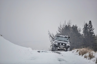 Black color jeep, snow off road, parked on  hill top