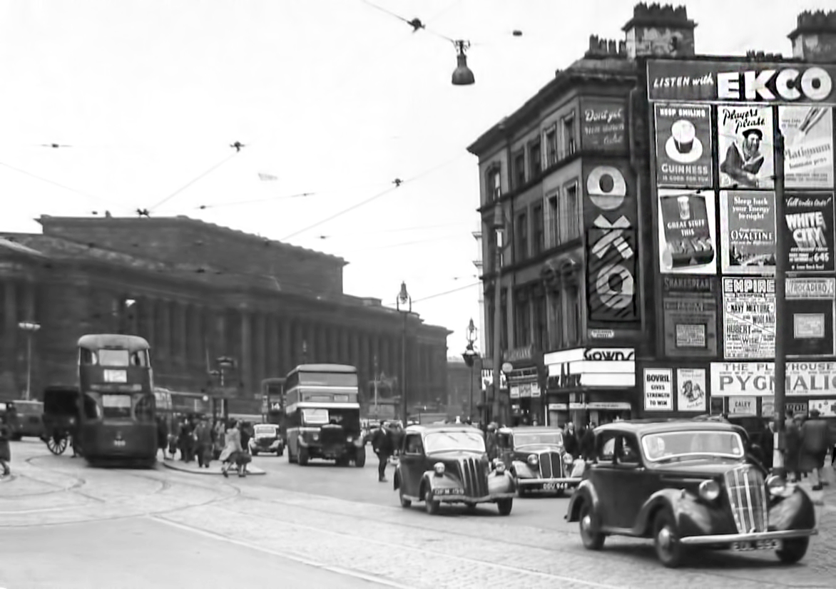 A busy Lime Street scene with cars, a tram and a bus.
A screen of old adverts can be seen on the right.