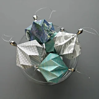 scrapbook patterned papers made into origami tree ornaments displayed in clear glass bowl