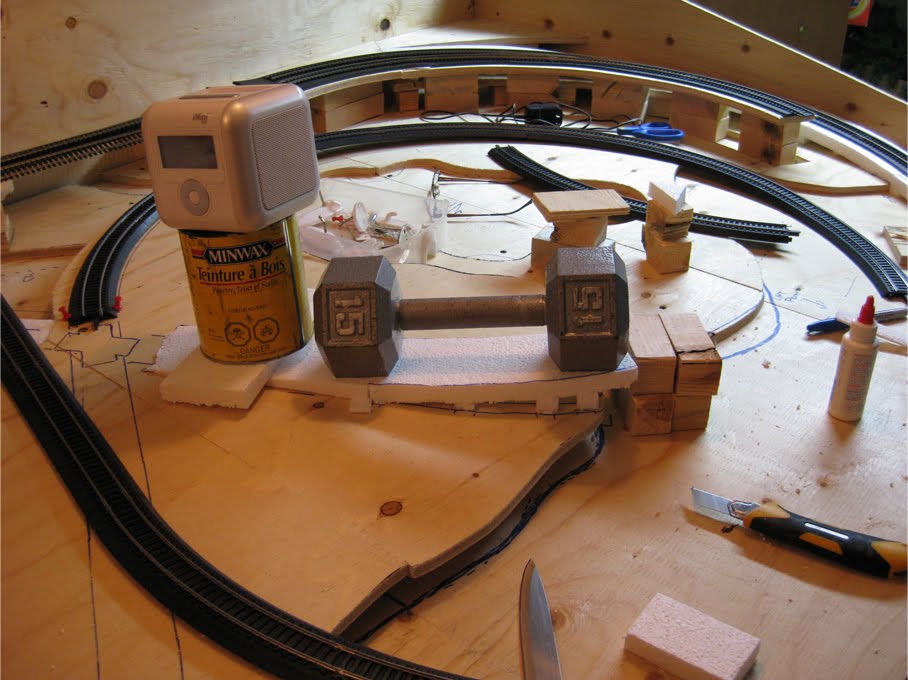 An expanded foam track riser being weighed down with a dumbbell while it dries