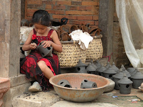 Small Nepali girl helps with creating pottery