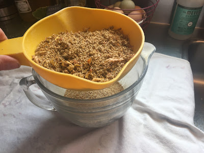winnowing quinoa with plastic strainer