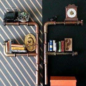 Two one-twelfth scale modern miniature pipe shelving units with different wallpaper behind them, and various books and objects on them.
