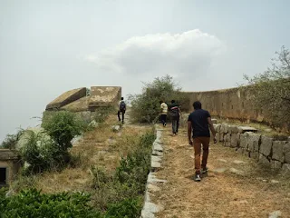 Hikers descending the steep stone steps of the fort
