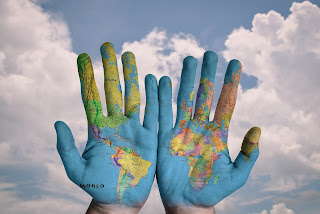 two hands with a world map painted in them
