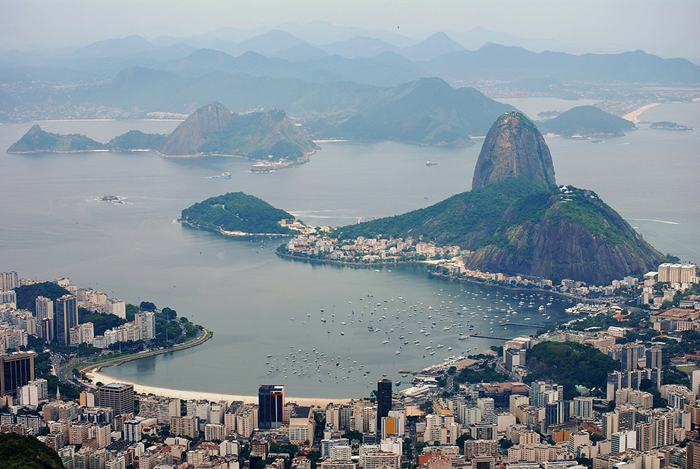 Sugarloaf Mountain, is a peak situated in Rio de Janeiro, Brazil, at the mouth of Guanabara Bay on a peninsula that sticks out into the Atlantic Ocean. Rising 396 metres (1,299 ft) above the harbor, its name is said to refer to its resemblance to the traditional shape of concentrated refined loaf sugar.