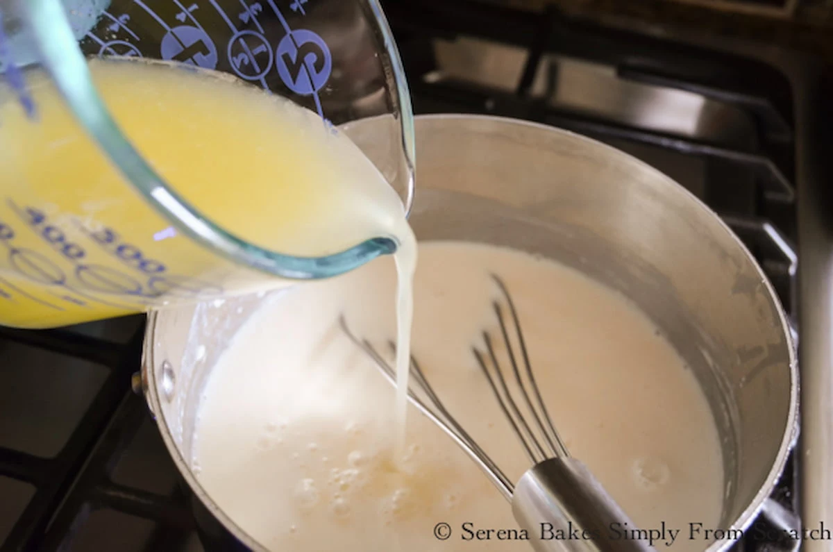 Lemon Juice being whisked into pudding mixture for Lemon Pudding.