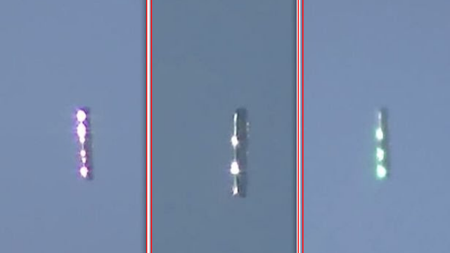 Cigar shaped UFO changes colour in mid air.