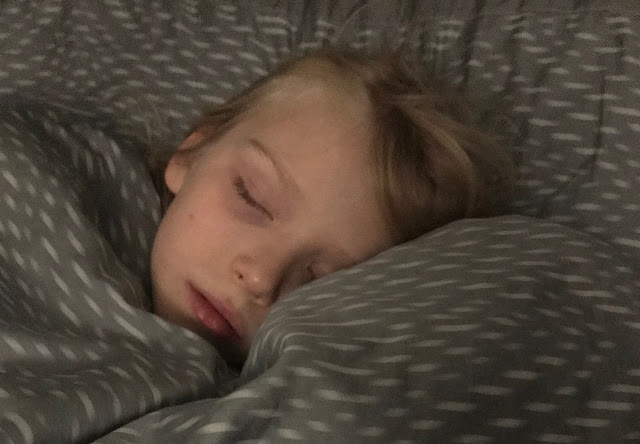 A child snuggled up in bed