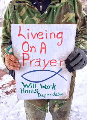man holding a living on a prayer sign