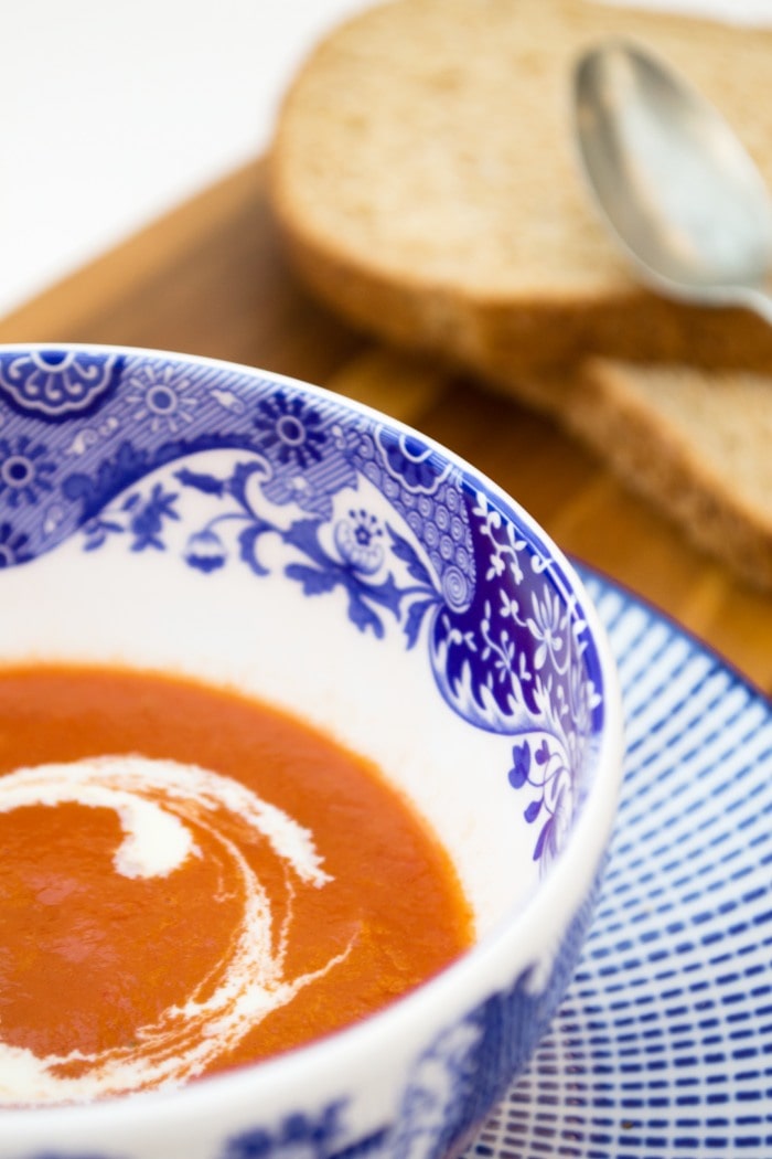 Easy vegan tomato soup A bowl of tomato soup next to slices of brown bread