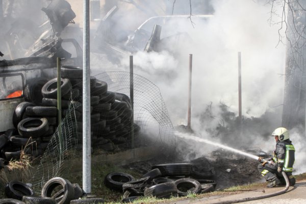 Ugunsdzēsējs dzēš ugunsgrēku autoservisā Ogrē