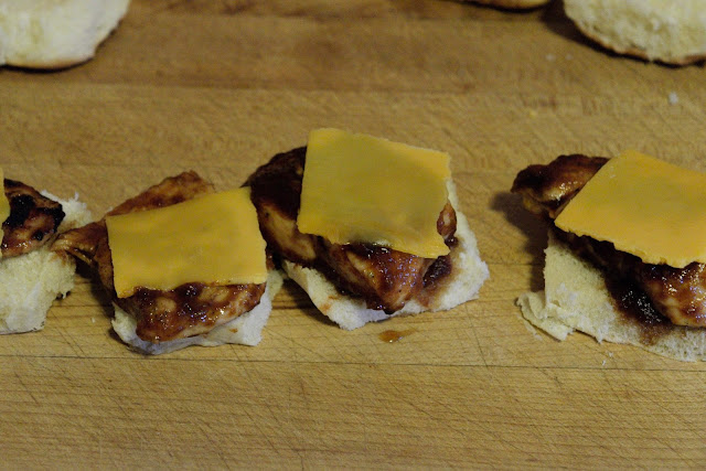 Cheese being added to the bbq chicken sliders.